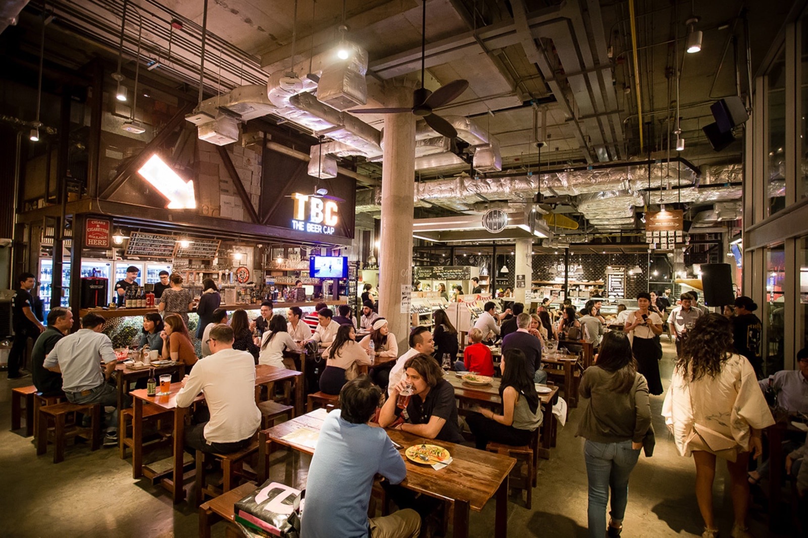 Inside The Beer Cap: communal tables under the TBC sign